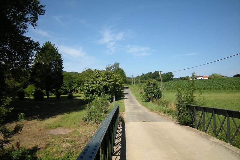 Der chemin du Moulin d'Iburre (ex. chemin d'Ibure) entlang dem Grundstück von der Brücke über den Lihoury gesehen