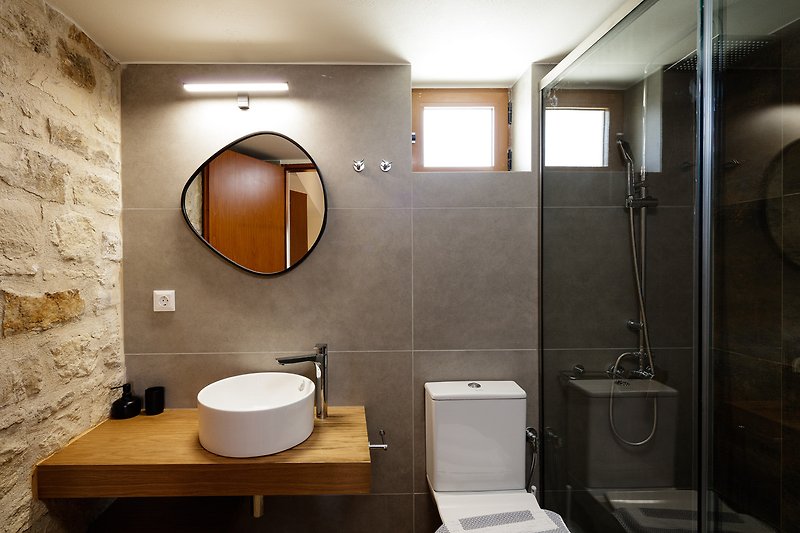 A modern bathroom with stylish fixtures and a sleek mirror.