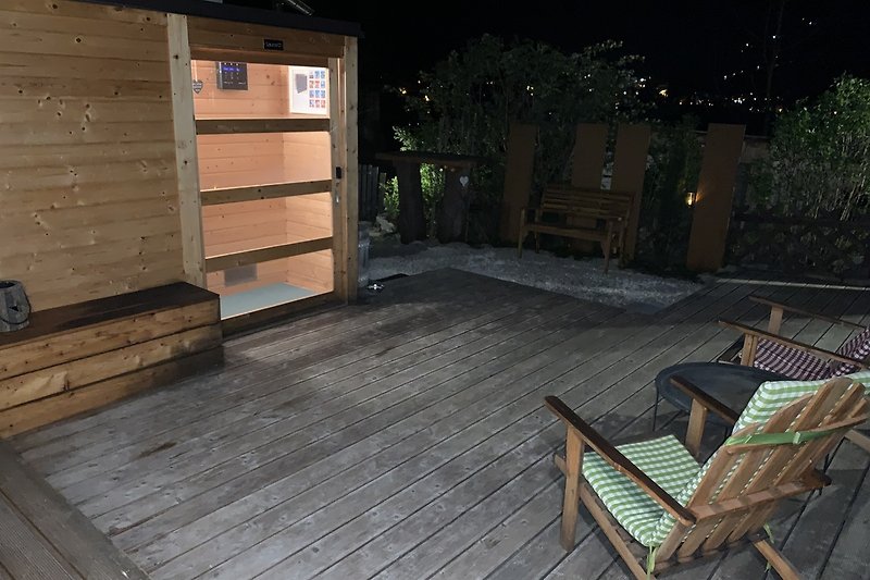 Sauna mit Holzdeck bei Nacht mit Blick  auf Bad Gastein