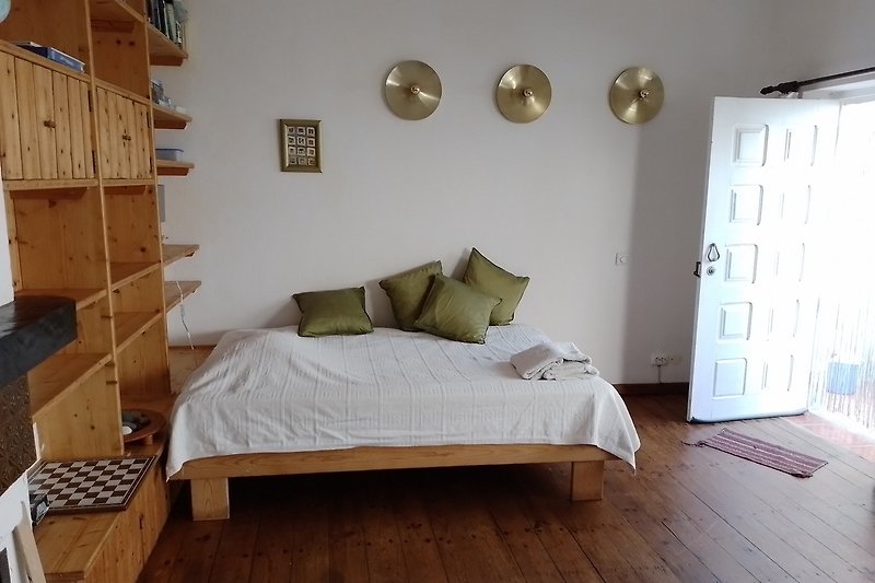 Modernes Schlafzimmer mit grauem Bettgestell, bequemem Bett und Holzmöbeln.