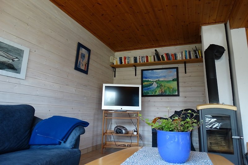 Wohnzimmer mit Kaminofen und gemütlicher Einrichtung und Ausgang zur Terrasse