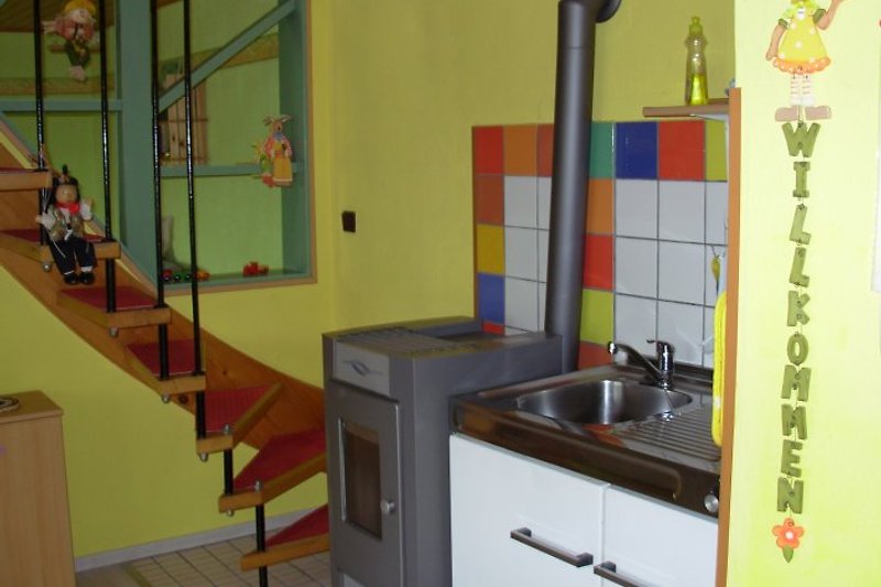 Küche mit Pelletsofen u. Treppe zu den Schlafzimmern