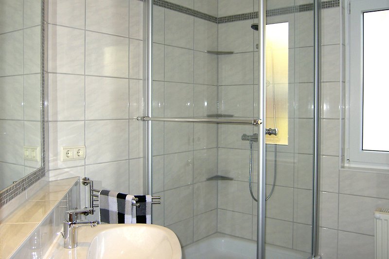 Bad mit Dusche und großem Spiegel