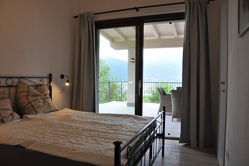 Schlafzimmer mit Blick über Terrasse auf See