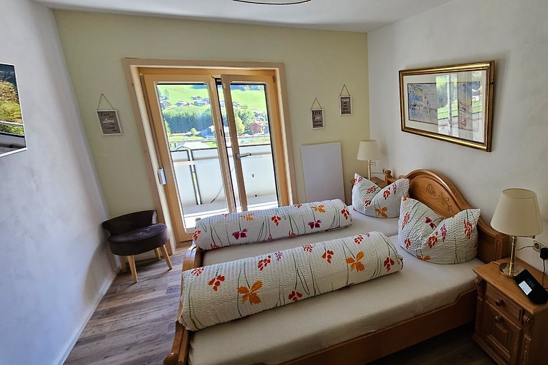 Gemütliches Schlafzimmer mit Holzbett, Fenster und Pflanze.