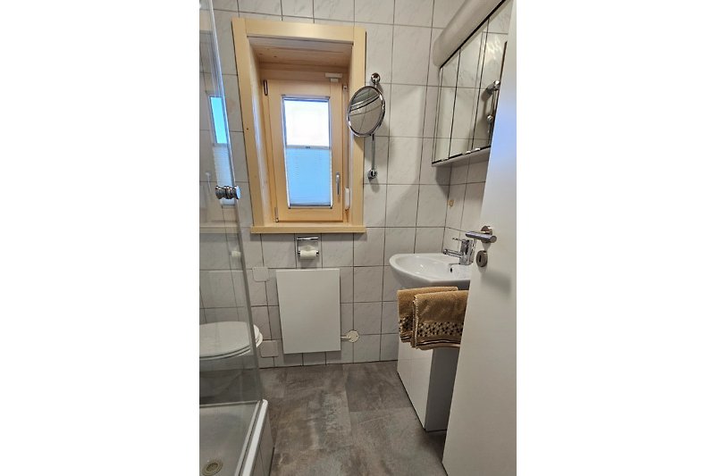 Ein stilvolles Badezimmer mit Spiegel, Waschbecken und Fenster