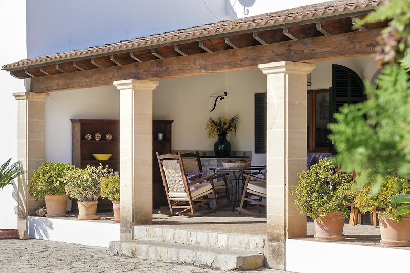 Einladende Terrasse mit bequemen Möbeln und blühenden Pflanzen.