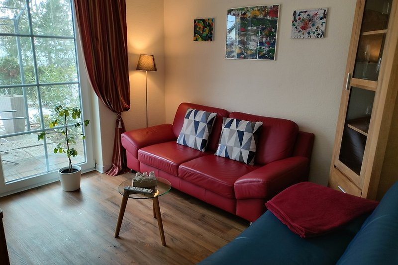 Gemütliches Wohnzimmer mit blauer Couch, Holzmöbeln und gemütlicher Beleuchtung.
