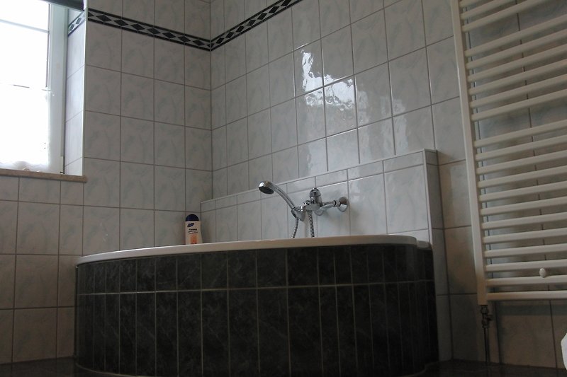 Badezimmer im EG mit Badewanne und Dusche.