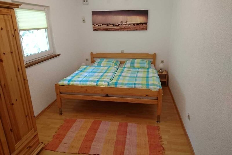 Ein gemütliches Schlafzimmer mit Holzboden und bequemem Bett.