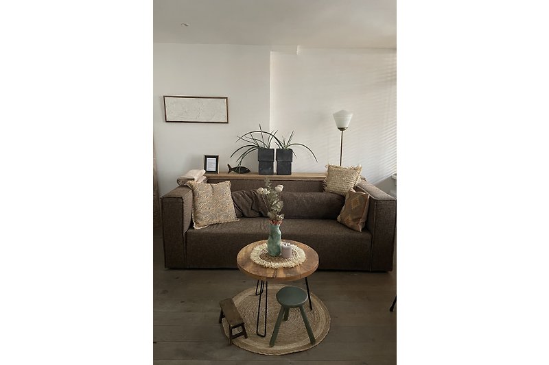 Gemütliches Zimmer mit Holzmöbeln, Metallregal und stilvollen Details.