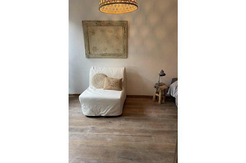 Gemütliches Zimmer mit Holzmöbeln, Metallregal und kunstvollen Details.