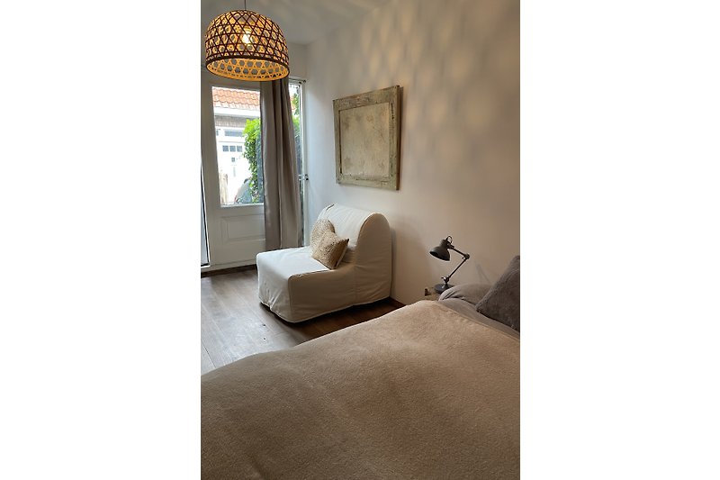 Gemütliches Wohnzimmer mit Holzmöbeln, bequemen Textilien und stilvoller Beleuchtung.
