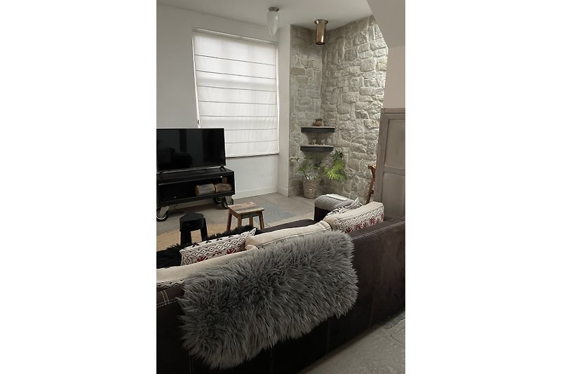 Moderne Wohnung mit stilvollem Design, grauen Wänden, Holzboden und Kunstwerken.