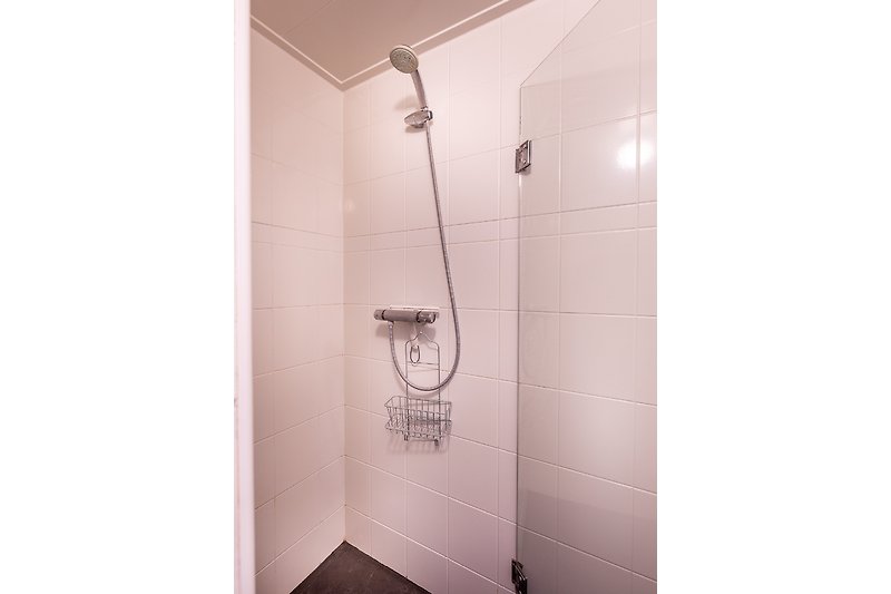 Badezimmer mit lila Dusche, Keramikfliesen und Glasduschkopf.