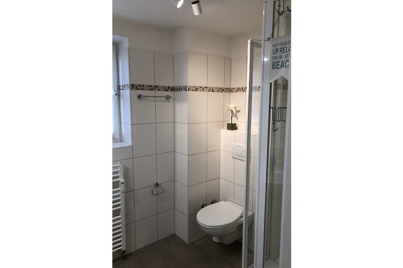 Modernes Badezimmer mit Dusche, Glaswand, Handtuchtrockner und Fenster