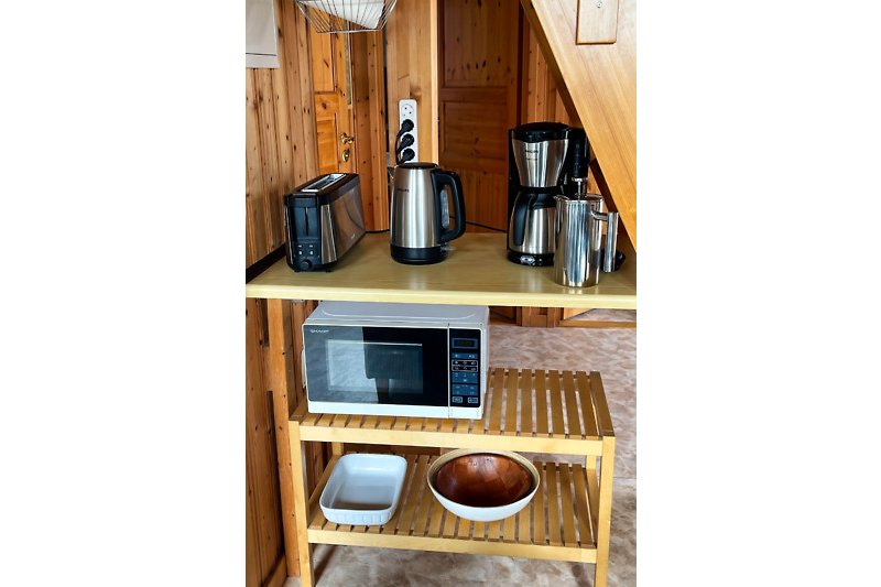 Moderne Küche mit Holzmöbeln und Fernseher.