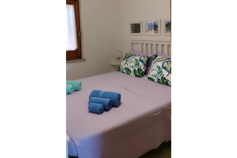Una camera da letto confortevole con arredamento in legno e biancheria di alta qualità.