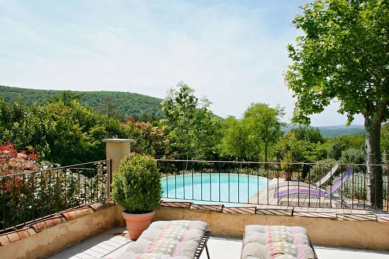 Blick von der überdachten Terrasse auf sen Pool