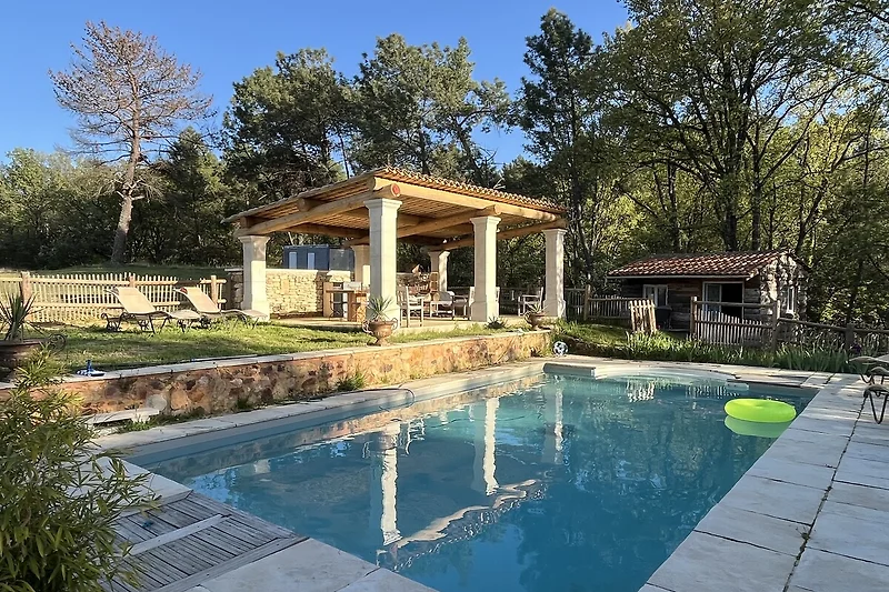 Pool mit schattiger Sitzecke vor der Villa im Grünen
