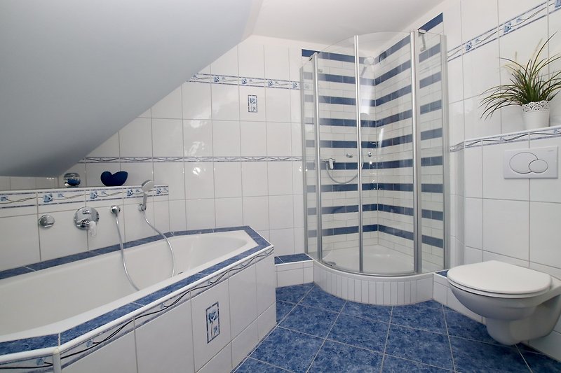 Ein modernes Badezimmer mit Badewanne, Dusche und stilvoller Einrichtung.