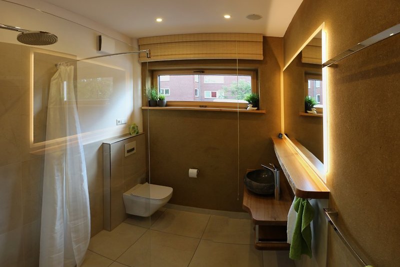 Das Badezimmer mit bodenebener Rainshower-Dusche.