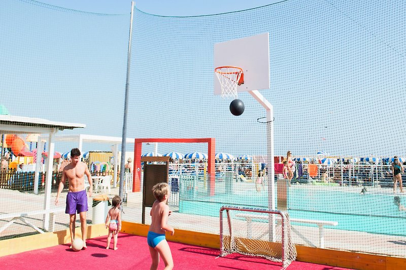 Am Strand Schöner Sportplatz mit Basketballkorb und Volleyballnetz. Aktive Freizeitgestaltung im Freien.