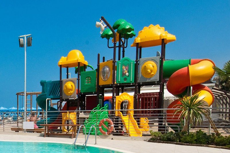 Schöner Pool mit Wasserrutsche Kinderspielplatz am Strand