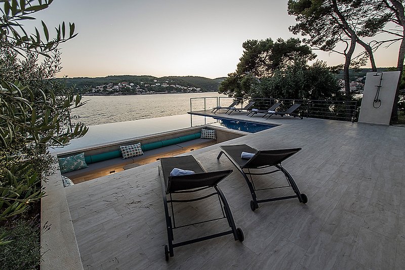 Relax by the water with outdoor furniture and a beautiful sunset.