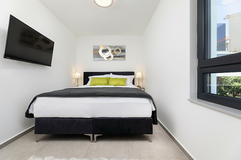 Entspannen Sie auf dem bequemen Bett und genießen Sie die angenehme Beleuchtung in diesem stilvollen Schlafzimmer.