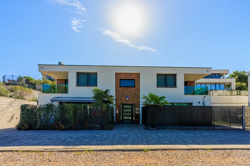 Große blaue Villa mit breiter Einfahrt und beeindruckender Architektur.