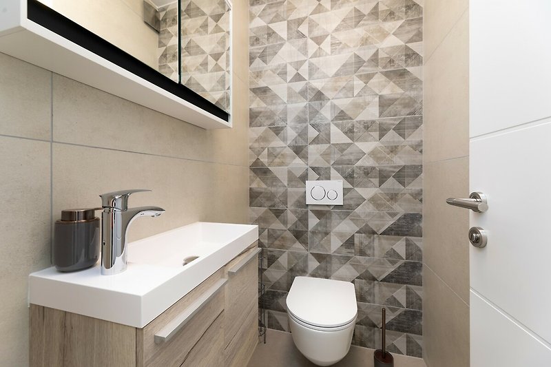 Gemütliches Badezimmer mit lila Waschbecken und Holzdetails. Entspannen Sie sich und genießen Sie die moderne Einrichtung.