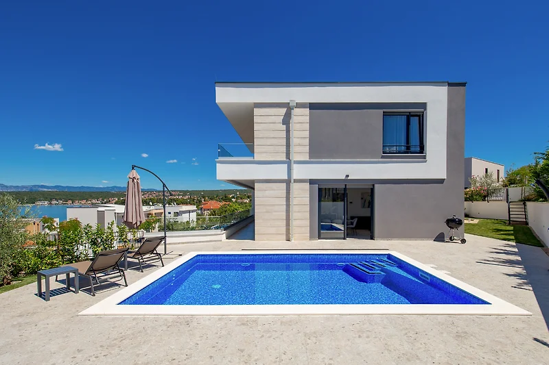 Weitläufige Anlage mit Pool, Villa und großzügigem Balkon.