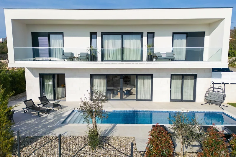Balkon mit Blick auf Pool und Anwesen im exklusiven Wohngebiet.