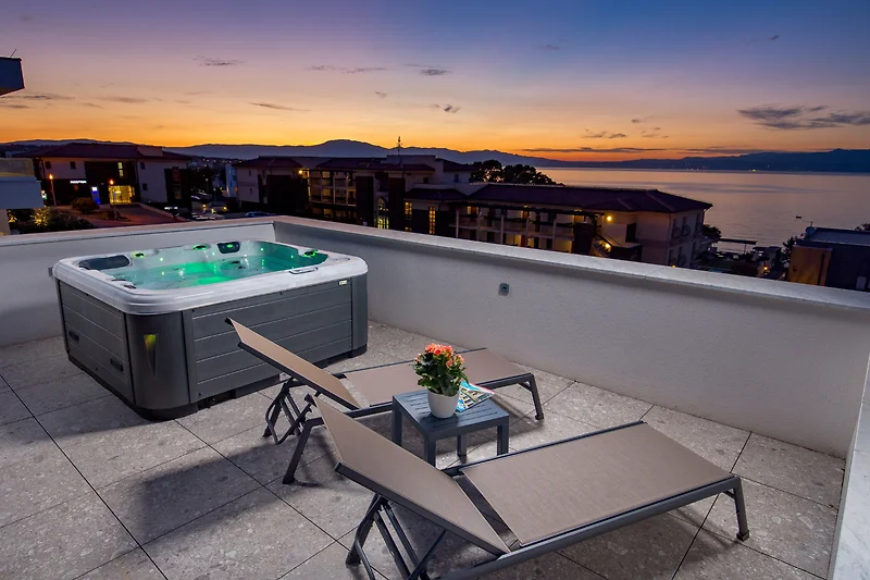 Boutique-Hotel: Balkon mit Whirlpool und Blick auf das nächtliche Resort.
