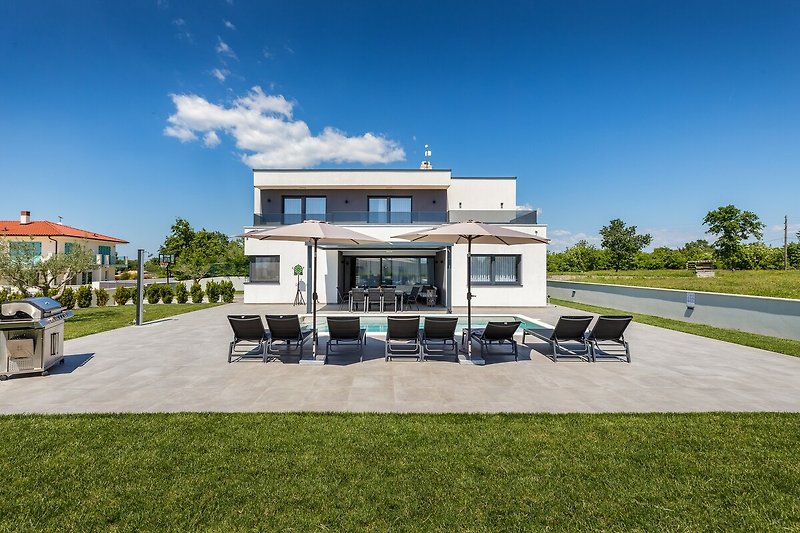 Royale villa met verzorgde tuin en schaduwrijke plekken.