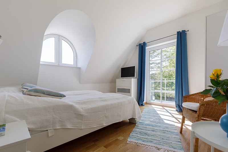 Gemütliches Schlafzimmer mit Holzmöbeln und blauen Vorhängen.