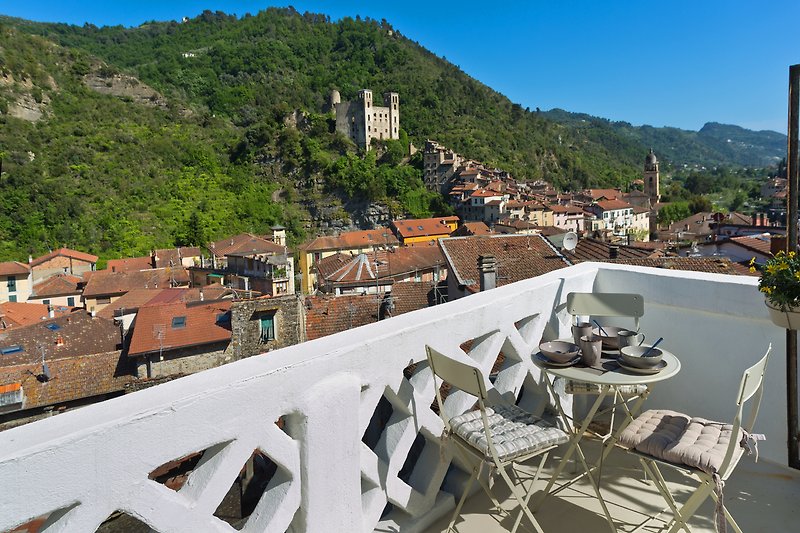 Atemberaubende Aussicht auf Berge, Stadt und stilvolle Outdoor-Möbel.