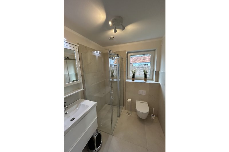 Modernes Badezimmer im EG mit Spiegel und Glasdusche, Waschmaschine und Trockner