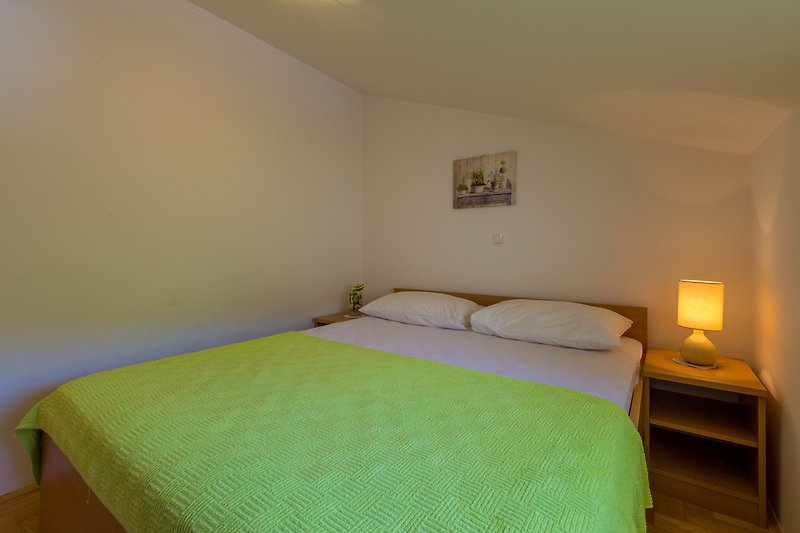 Gemütliches Schlafzimmer mit bequemem Bett, stilvoller Einrichtung und Holzboden.