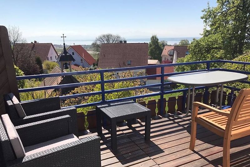 Balkonansicht mit See- und Alpenpanorama und Lounge-Möbeln