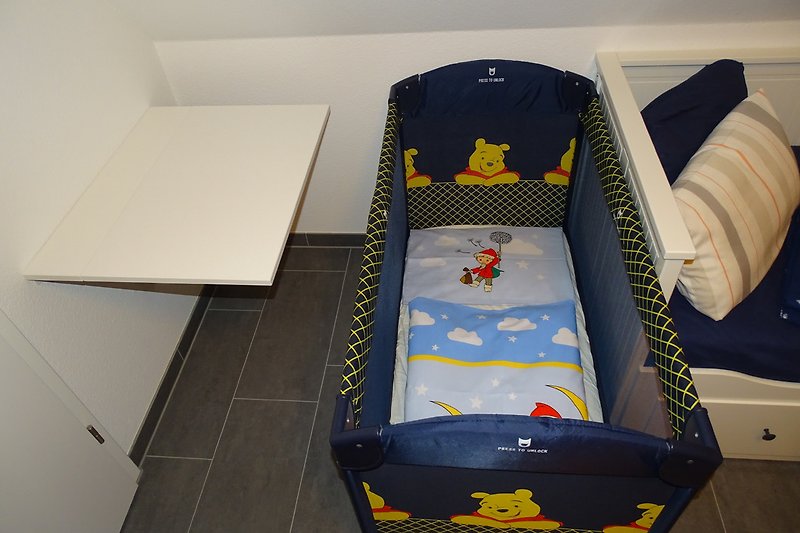 Dostępne są łóżeczko dla niemowląt, pościel i pościel do łóżeczka.