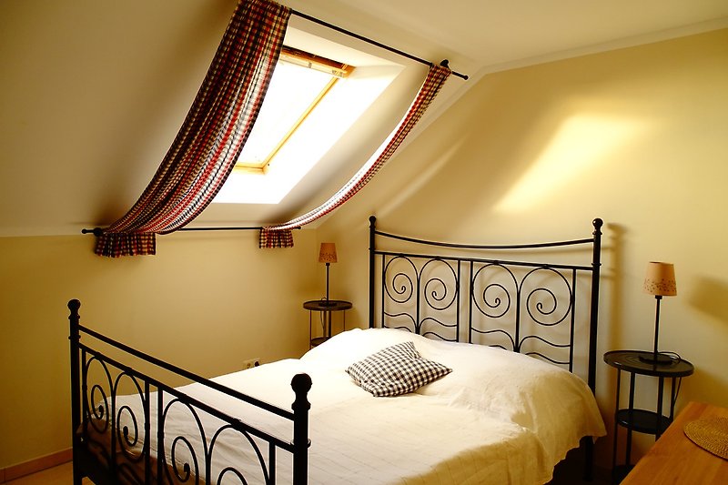 Schlafzimmer mit Doppelbett, Dachfenster mit Verdunklungsplissee