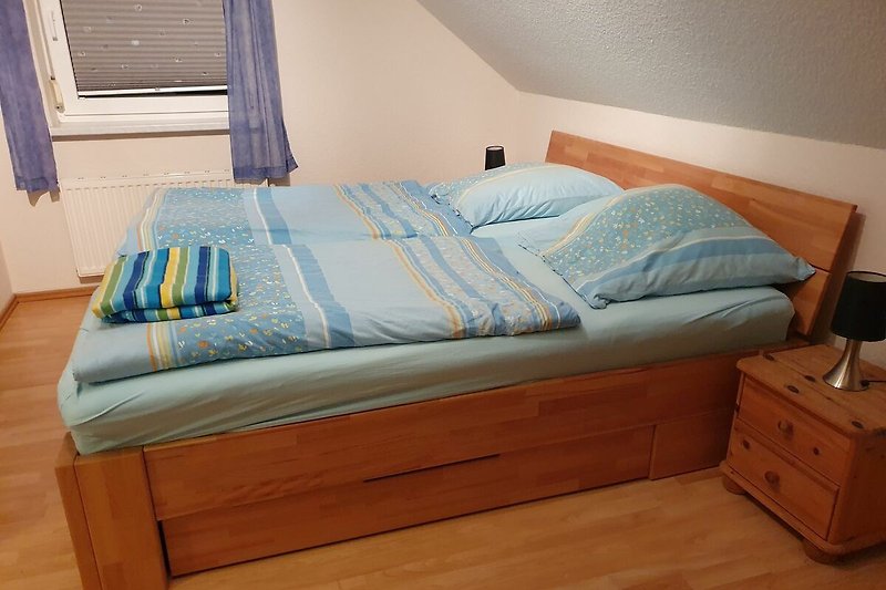 Ein komfortables Schlafzimmer mit Holzboden und einem gemütlichen Bett.