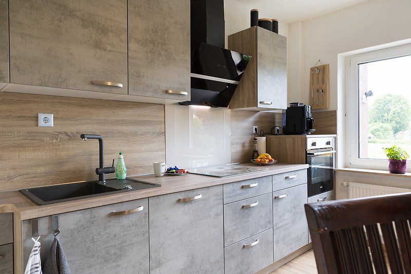 Moderne Küche mit hochwertigen Geräten und stilvollem Design. Genießen Sie das Kochen und die Aussicht.