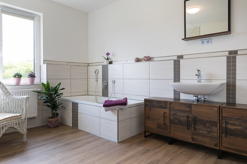 Ein stilvolles Badezimmer mit lila Akzenten und modernem Design. Entspannen Sie sich am Waschbecken und genießen Sie den Komfort.