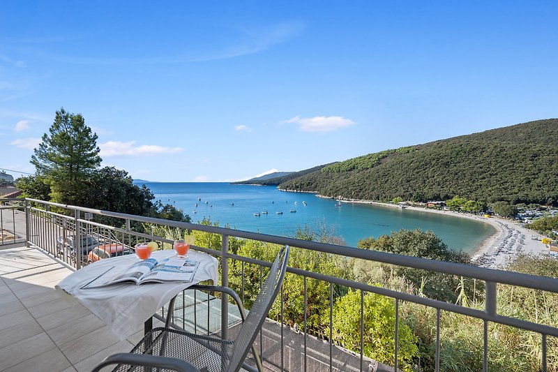 Luxuriöser Pool mit Blick auf die Bucht und tropische Landschaft.