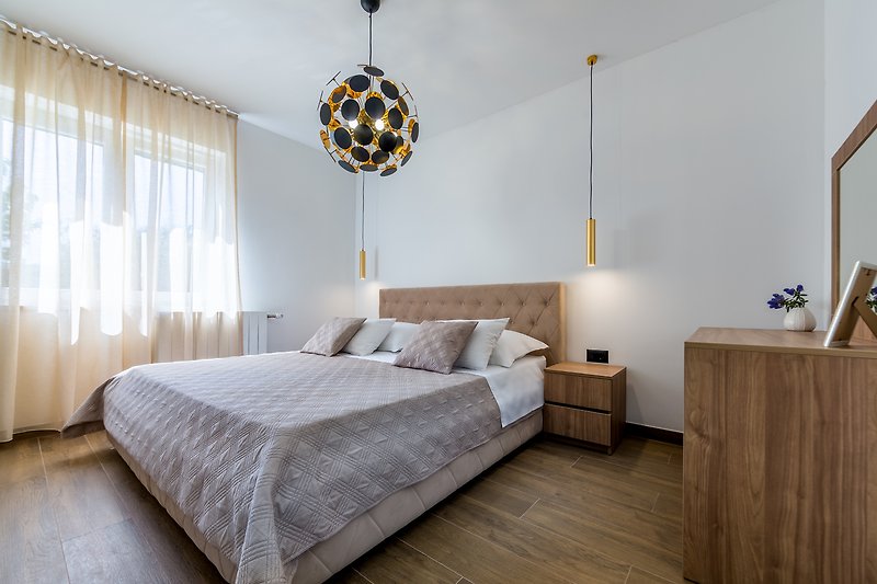 Elegantes Schlafzimmer mit Holzmöbeln und gemütlicher Beleuchtung.
