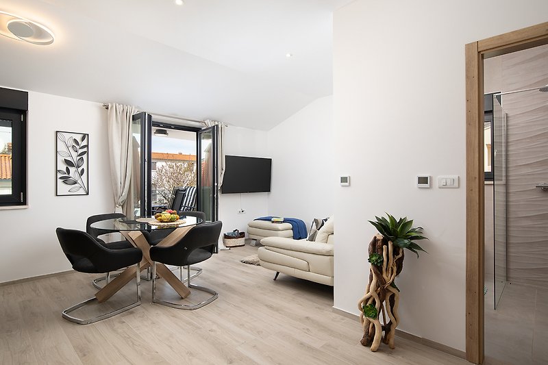 Moderne Wohnung mit stilvollem Interieur, Holzboden und Pflanzendeko.