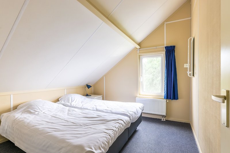 Ein stilvolles Schlafzimmer mit gemütlichem Bett und Holzboden.